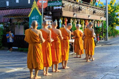 Photo for Lampang, Thailand - December 2, 2023: Thai Theravada Buddhist monks walking for morning alms in Nakhon Lampang, Thailand. - Royalty Free Image