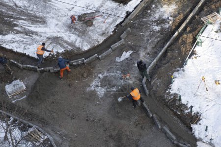 Téléchargez les photos : Ukraine, Kiev, 01.12.2022 : réparation de la route pendant la guerre. Les travailleurs réparent la route dans la ville de Kiev en hiver, pendant la guerre. Photo de haute qualité - en image libre de droit