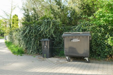 Téléchargez les photos : Garbage cans of different sizes stand on the street. The idea of sorting garbage and cleaning the territory. High quality photo - en image libre de droit