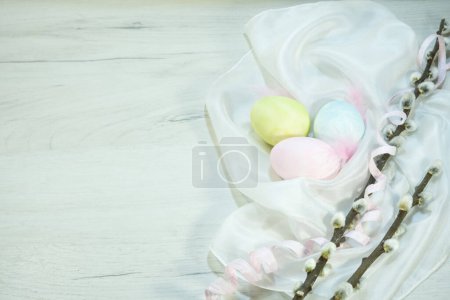 Téléchargez les photos : Three colorful eggs with willow branches lie on the table. Festive composition for Easter. High quality photo - en image libre de droit