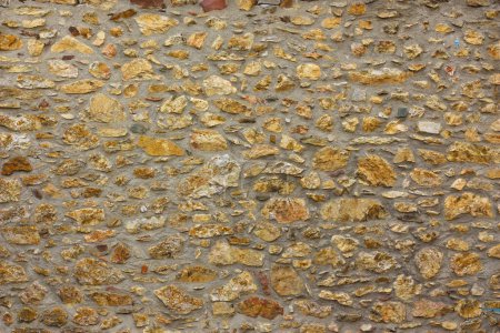 Téléchargez les photos : Un mur de petites pierres. Le fond est fait de pierres et de ciment. Photo de haute qualité - en image libre de droit
