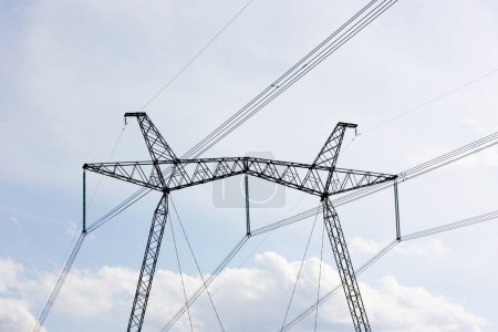 Electric poles with wires against the sky with clouds. The idea of providing electricity to the population. High quality photo