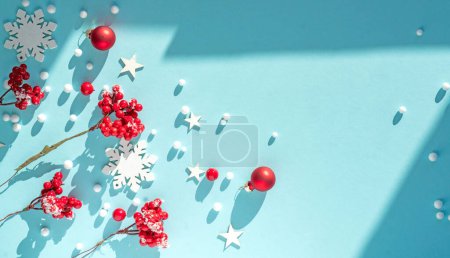 Photo for Beautiful light blue Christmas background with red berries and snowflakes. New Year's composition with decorations for Happy New Year. - Royalty Free Image