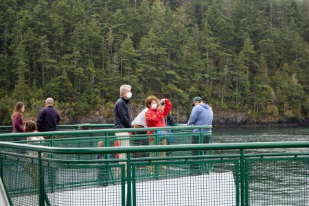 Photo for Anacortes, Washington, United States - 09-11-2021: A view of people enjoying the open deck of a ferry boat. - Royalty Free Image