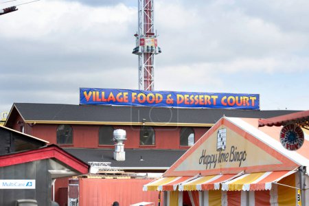 Téléchargez les photos : Puyallup, Washington, United States - 09-13-2021: A view of a sign letting guests know about the area for the Village Food and Dessert Court, seen at the Washington State Fair. - en image libre de droit