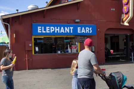 Téléchargez les photos : Puyallup, Washington, United States - 09-13-2021: A view or people looking at an elephant ears carnival snack vendor and sign. - en image libre de droit
