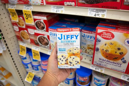 Téléchargez les photos : Los Angeles, Californie, États-Unis - 20-05-2022 : Vue d'une main tenant un paquet de mélange de muffins aux myrtilles Jiffy, exposé dans une épicerie locale. - en image libre de droit