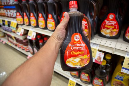 Photo for Los Angeles, California, United States - 05-20-2022: A view of a hand holding a bottle of Pearl Milling Company syrup, on display at a local grocery store. - Royalty Free Image