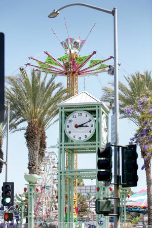 Téléchargez les photos : Garden Grove, Californie, États-Unis - 30-05-2022 : Une vue sur la tour de l'horloge Garden Grove au Village Green et une promenade palpitante en arrière-plan, pendant le festival des fraises. - en image libre de droit