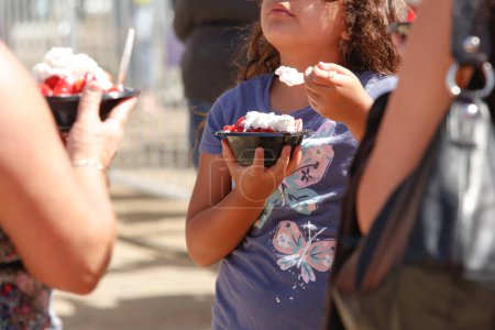 Téléchargez les photos : Garden Grove, Californie, États-Unis - 30-05-2022 : Une vue d'un client portant un bol de sablé aux fraises, un aliment de rue présenté au Festival des fraises. - en image libre de droit