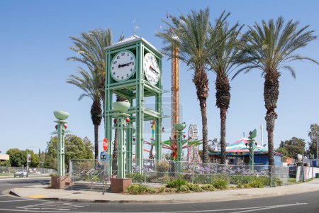 Téléchargez les photos : Garden Grove, Californie, États-Unis - 30-05-2022 : Une vue sur la tour de l'horloge Garden Grove au Village Green et une promenade palpitante en arrière-plan, pendant le festival des fraises. - en image libre de droit