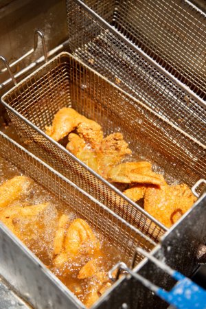 Photo for A view looking into a deep fryer machine full of fried chicken pieces. - Royalty Free Image