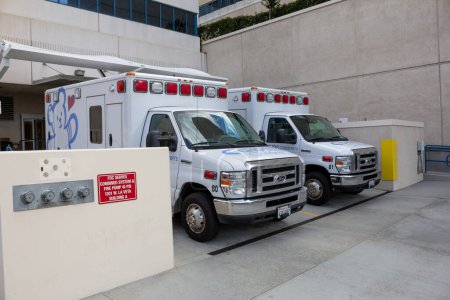 Foto de Orange, California, Estados Unidos - 03-10-2019: Una vista de un par de ambulancias, estacionadas en la parte trasera de un muelle de un hospital. - Imagen libre de derechos