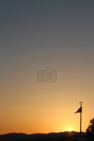 Silhouette einer Flagge auf dem Hintergrund der untergehenden Sonne