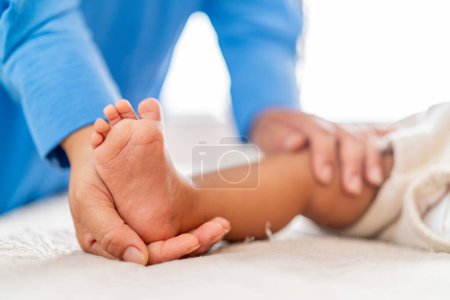 The delicate feet of a baby receiving a gentle touch, possibly during a soothing massage, emphasizing comfort and care.