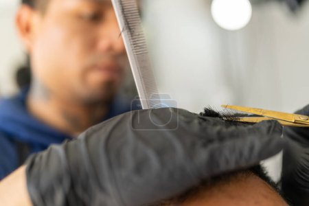 Close-up of scissors trimming the hair of a man in a barber shop