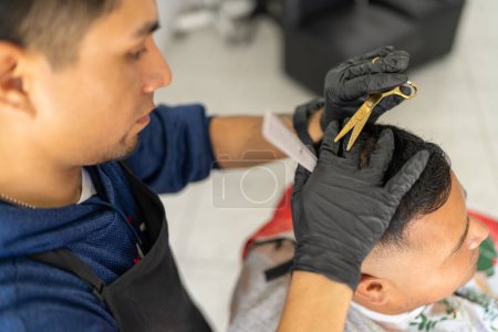 Photo for Elevated view of a latin barber cutting the hair of a client - Royalty Free Image