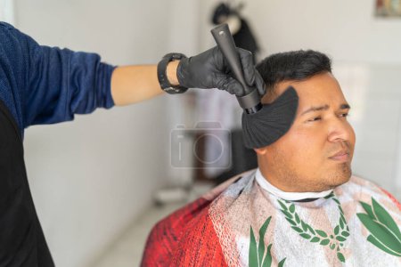 Barber cleaning the face of a client with a brush after cutting his hair