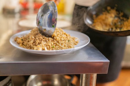 Primer plano de cocción de arroz Chaufa en un plato dentro de una cocina