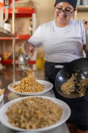 Vertical photo of a chef platting noddles ready to be served in a restaurant