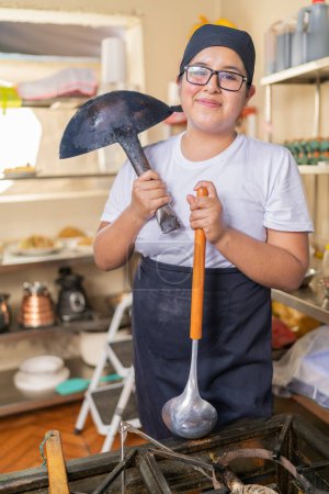 Vertikales Porträt eines Kochs, der Küchenutensilien hält und in die Kamera lächelt