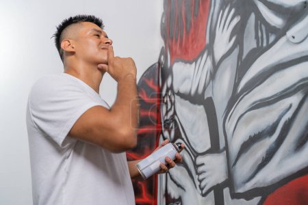 Doubtful artist looking at the mural he is painting with finger on chin