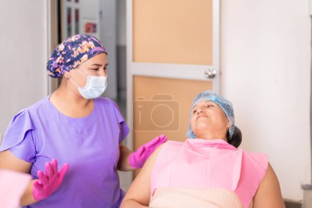 A smiling patient listens as her dentist explains dental procedures in a dental clinic environment