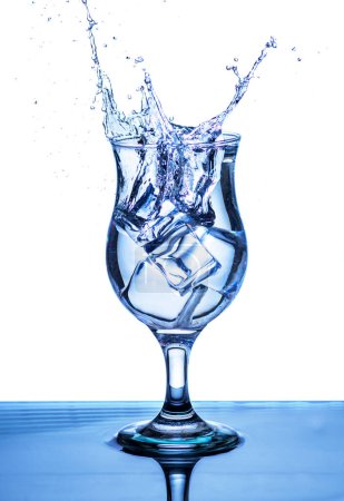Téléchargez les photos : The image of pouring drinking water, into a glass, that makes one feel refreshed on blurred white background, Splashing water, Sparkling water - en image libre de droit