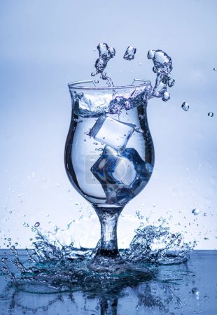 Téléchargez les photos : L'image de verser de l'eau potable, dans un verre cassé, qui permet de se sentir rafraîchi sur fond blanc flou, Eau éclaboussante, Eau pétillante - en image libre de droit