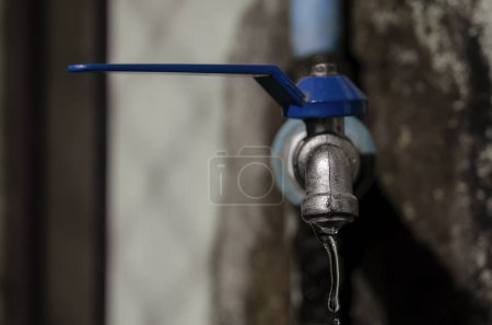 Photo for Wasting water - water drop from water tap, Leaky or tap, water tap in remote area, Deteriorated and dirty tap that everyone in the village uses to drink, which is located in a remote area It reflects the insufficiency of government agencies' water su - Royalty Free Image