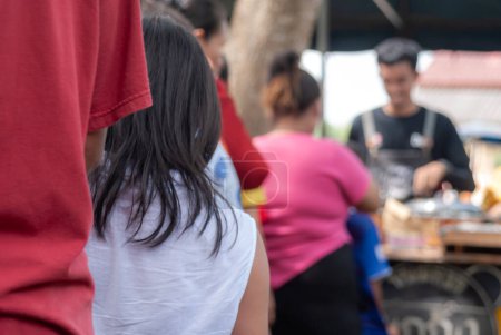 Foto de Personas que esperan recibir distribución de alimentos a personas que vienen al festival de méritos de Kathin en Tailandia - Imagen libre de derechos