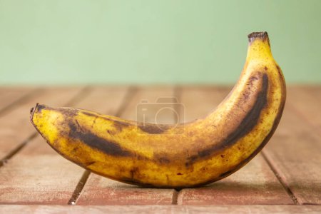 Rotten banana on wooden blurred background