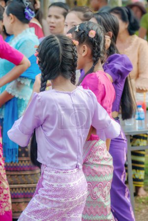 Foto de SURATTANI, TAILANDIA - NOV. 06, 2023: Vestido de niña birmana con trajes nacionales. Ven a participar en el festival de Kathin durante el final de la Cuaresma budista para los hermanos y hermanas birmanos en Tailandia. - Imagen libre de derechos