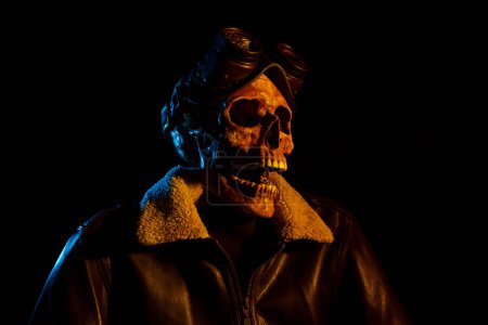Photo for Skull with leather jacket and steampunk goggles. Aviator costume. Colored light - Royalty Free Image