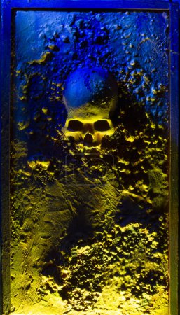 crâne encastré sur une surface texturée, lumières jaunes et bleues