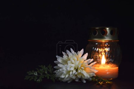 Photo for Burning candle and white chrysanthemum on dark background with copy space. Sympathy card - Royalty Free Image