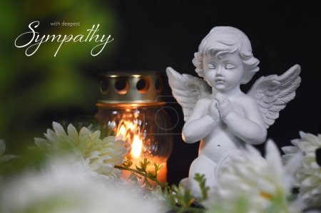 Tarjeta de simpatía con un ángel, vela votiva y flores sobre fondo negro