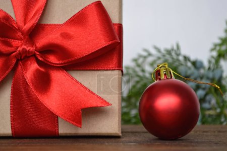 Foto de Caja de regalo con cinta roja y bola roja brillante, decoraciones de Navidad sobre fondo blanco - Imagen libre de derechos