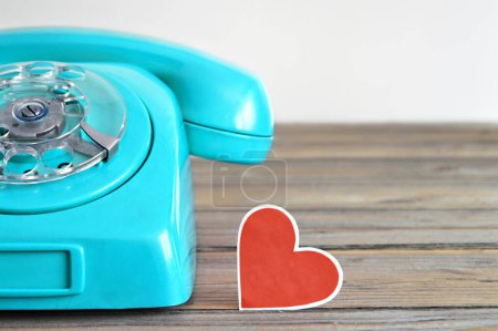 Photo for Blue retro telephone and heart decoration on wooden background - Royalty Free Image