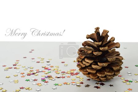 Téléchargez les photos : Composition de Noël de cône de pin et confettis colorés sur fond blanc. - en image libre de droit