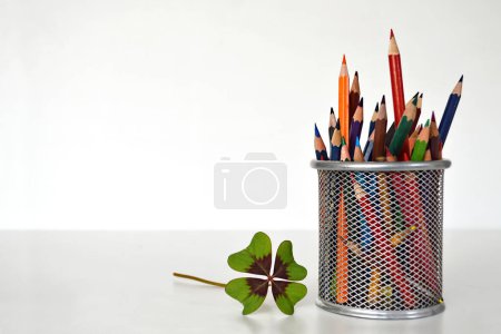 Photo for Colorful pencils and clover leaf isolated white background. - Royalty Free Image