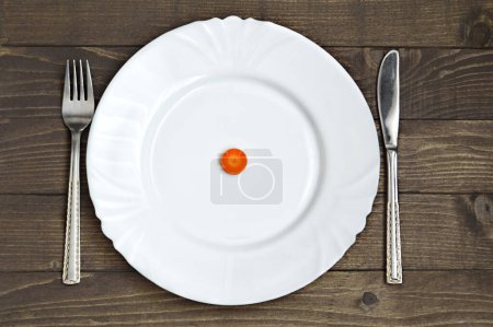 Photo for White plate, fork and knife on wooden table - Royalty Free Image