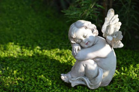 Téléchargez les photos : Statue d'ange mignon dans le jardin d'été - en image libre de droit