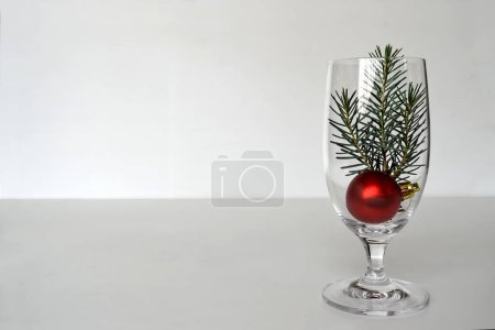 Photo for Christmas decorations on white background. Pine tree twigs and red shiny ball in wineglass, christmas and new year card - Royalty Free Image