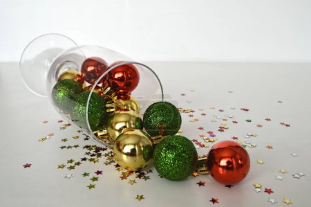 Téléchargez les photos : Nouvelle année modèle de carte, verre de champagne avec boules de Noël et confettis sur fond blanc - en image libre de droit