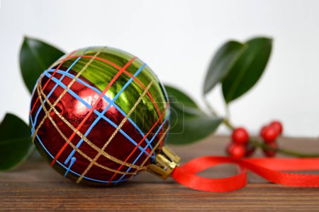 Foto de Decoración de Navidad. bola de Navidad brillante y rama verde en la mesa de madera - Imagen libre de derechos