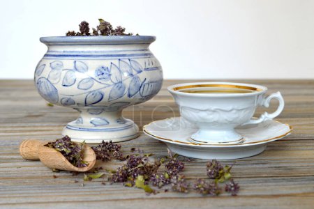 Photo for Melissa tea with dry herbs on wooden table - Royalty Free Image