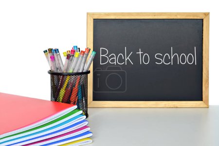 Photo for Education concept. back to school text written on blackboard, color pens in container and bright copybooks on table - Royalty Free Image
