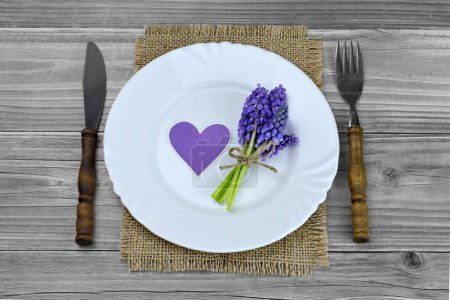 Foto de Decoración de la mesa de primavera, corazón púrpura pegatina y flores de Muscari en el plato - Imagen libre de derechos