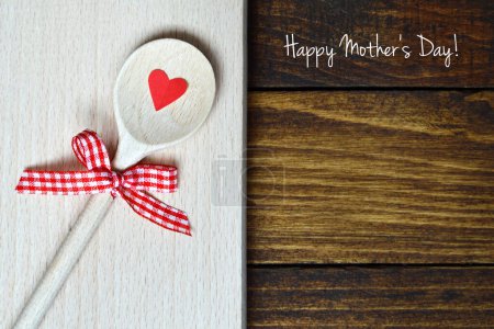 Foto de Feliz tarjeta del Día de la Madre con primicia de madera rústica, símbolo rojo del corazón y lazo rojo - Imagen libre de derechos
